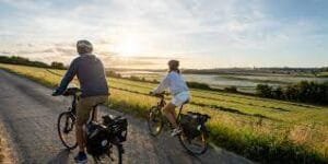 vélo Deux personnes à vélo sur une route au coucher du soleil
