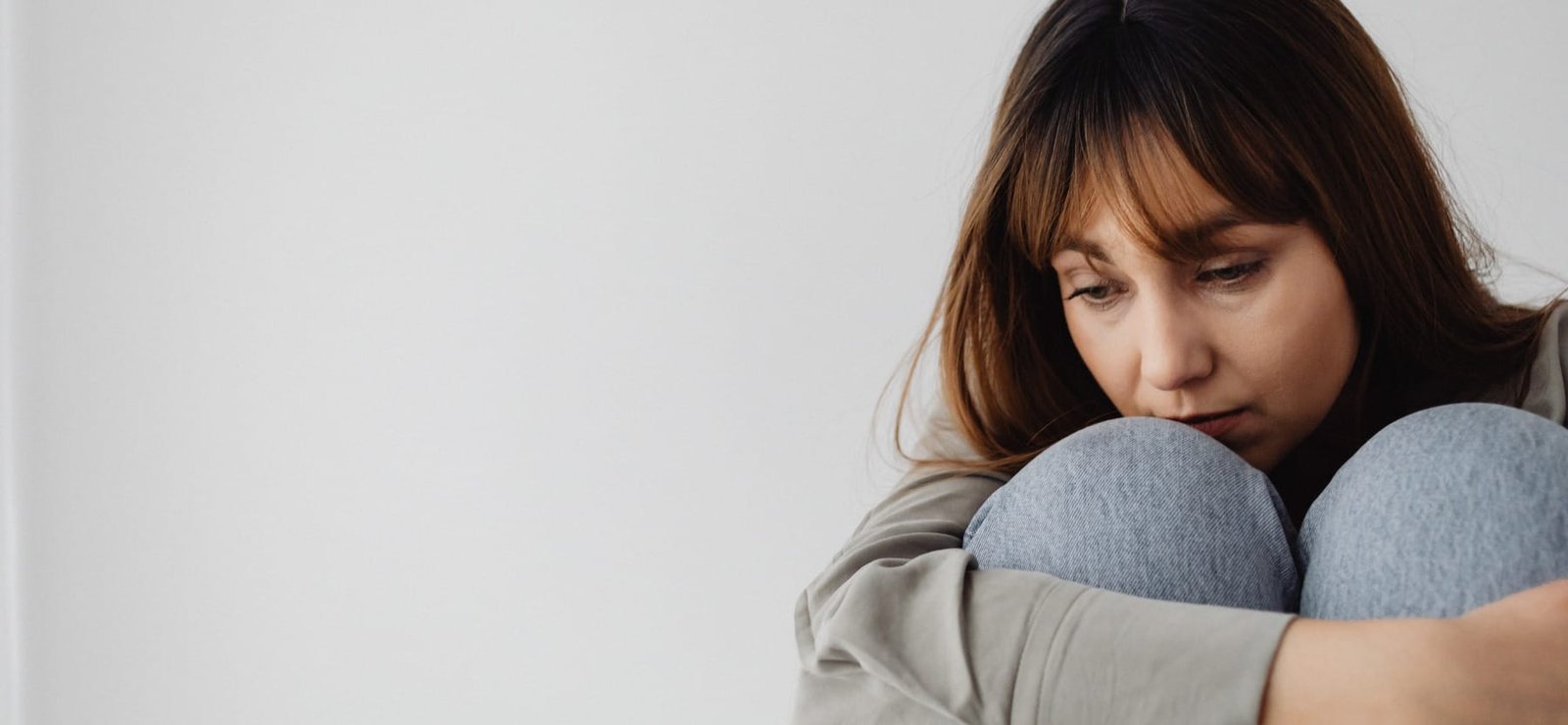 Une jeune femme assise seule est entrain de penser à cause d'une dépression