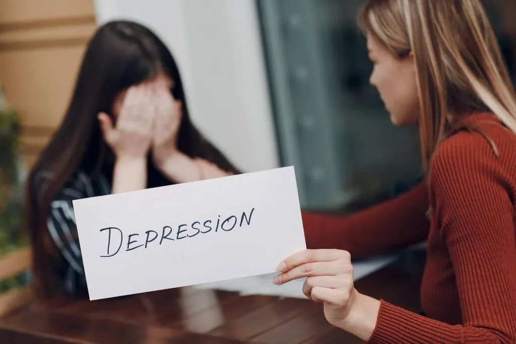 concept-cache-depression-stress-femme-qui-pleure-deuxieme-femme-tenant-feuille-papier-blanc-etiquete-mot-depression-main-1024×683 Une fille exprime qu'elle est atteinte d'une dépression