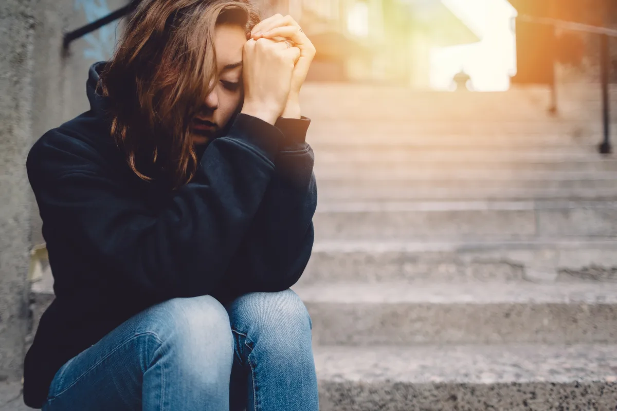 sad-girl-on-steps Une femme atteinte d'une dépression est assise seule sur une marche