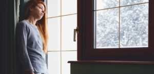 Une femme atteinte de dépression, seule face à la fenêtre