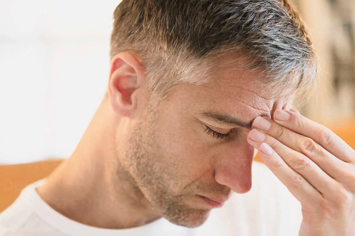 close-up-of-man-with-headache-touching-forehead-CAIF15954 Un homme seule dans un état de dépression.