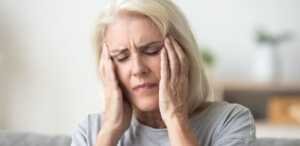 Une femme sénior plongée dans une dépression se prend la tête