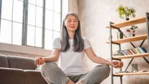 Grey-haired mature caucasian woman meditating at home Comment agit-il?
