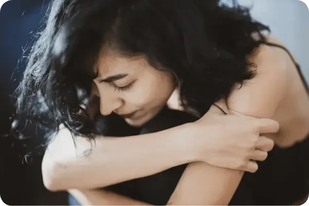 Femme triste serrant ses genoux