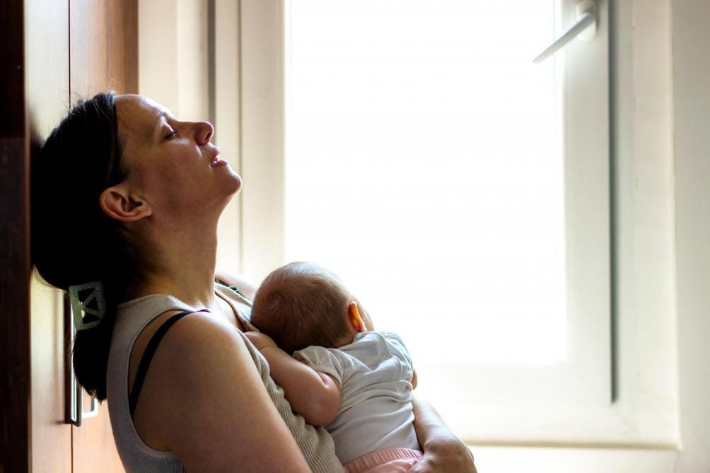 B9732764273Z.1_20221124190032_000+GV1LNV21H.1-0 Une mère épuisée et déprimée qui tient son bébé contre elle.