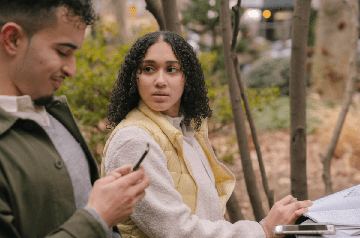 Une femme dévisageant son compagnon qui ne lui porte aucune attention