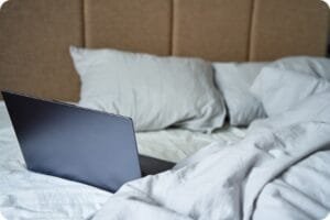 Ordinateur portable posé sur un lit défait