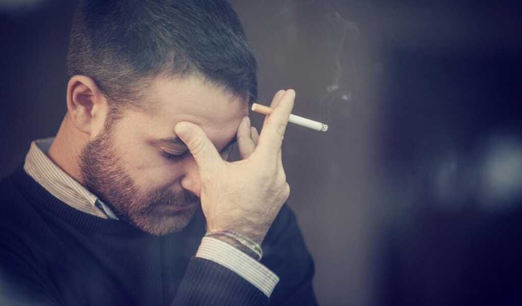 Worried man smoking a cigarette Comment agit-il?