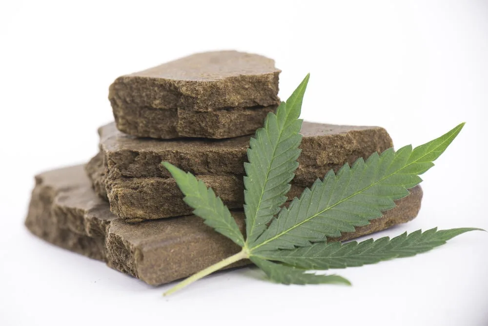 Hash-Block-and-cannabis-leaf Le hasch: un produit tiré des extraits de cannabis.