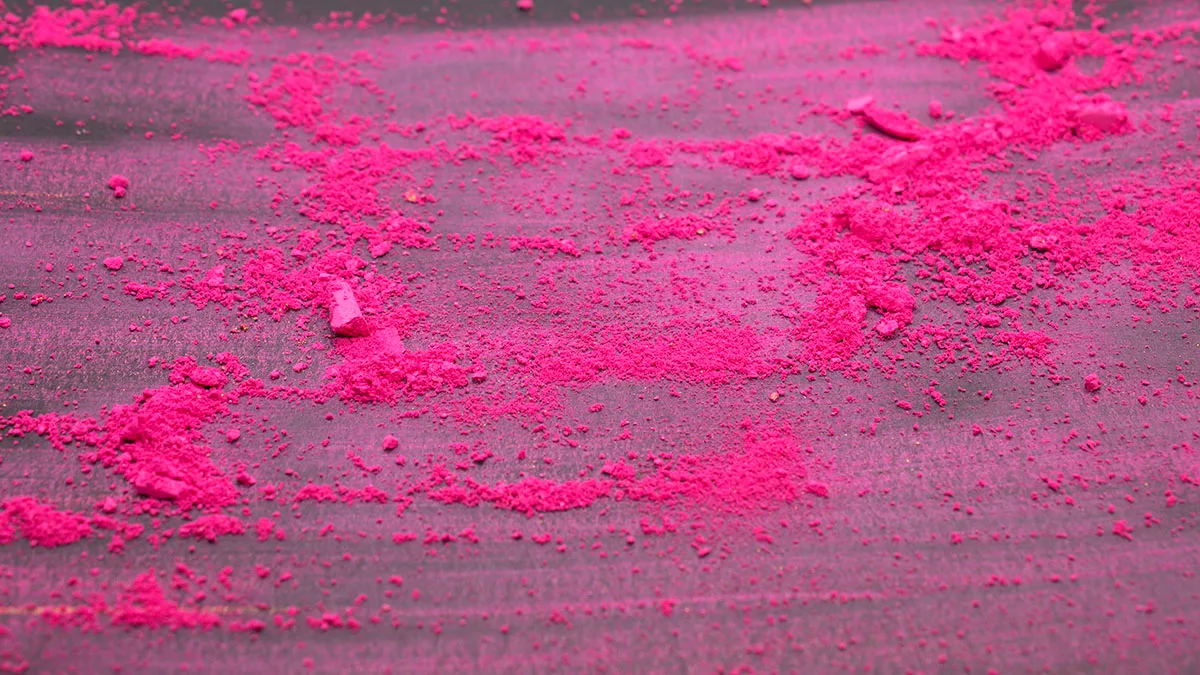 This is a photograph of a Pink powder eyeshadow isolated on a Black background La drogue 2C-B en poudre rose répandue sur un table.