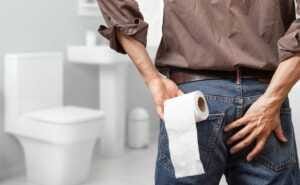 man holding toilet tissue roll in bathroom looking at loo Le sevrage s'accompagne de symptômes et d'effets indésirables, dont la constipation.