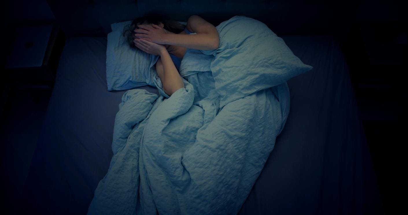 iStock-1403985843 Une personne dans un état dépressif, allongée dans son lit.