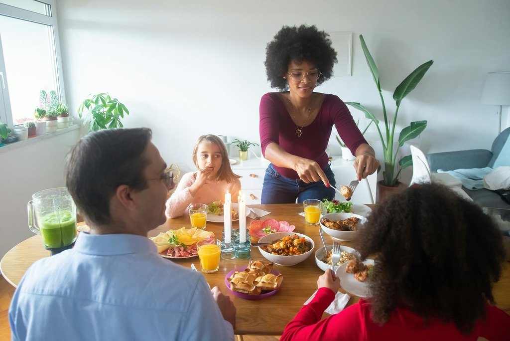 A diverse family sharing a warm homemade meal around a beautifully set table indoors.