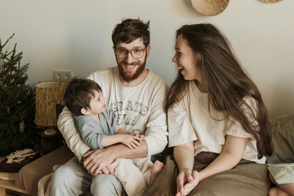 Happy family enjoying time together indoors, capturing genuine smiles and warm embraces.
