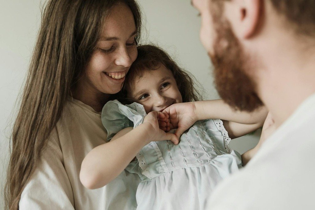 Heartwarming family portrait of mother and daughter embracing joyfully indoors.