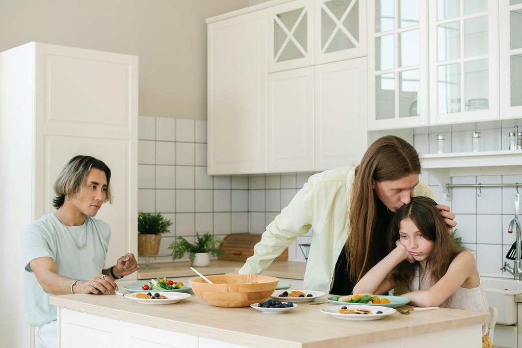 A family enjoys breakfast together in a bright, modern kitchen setting, emphasizing togetherness.